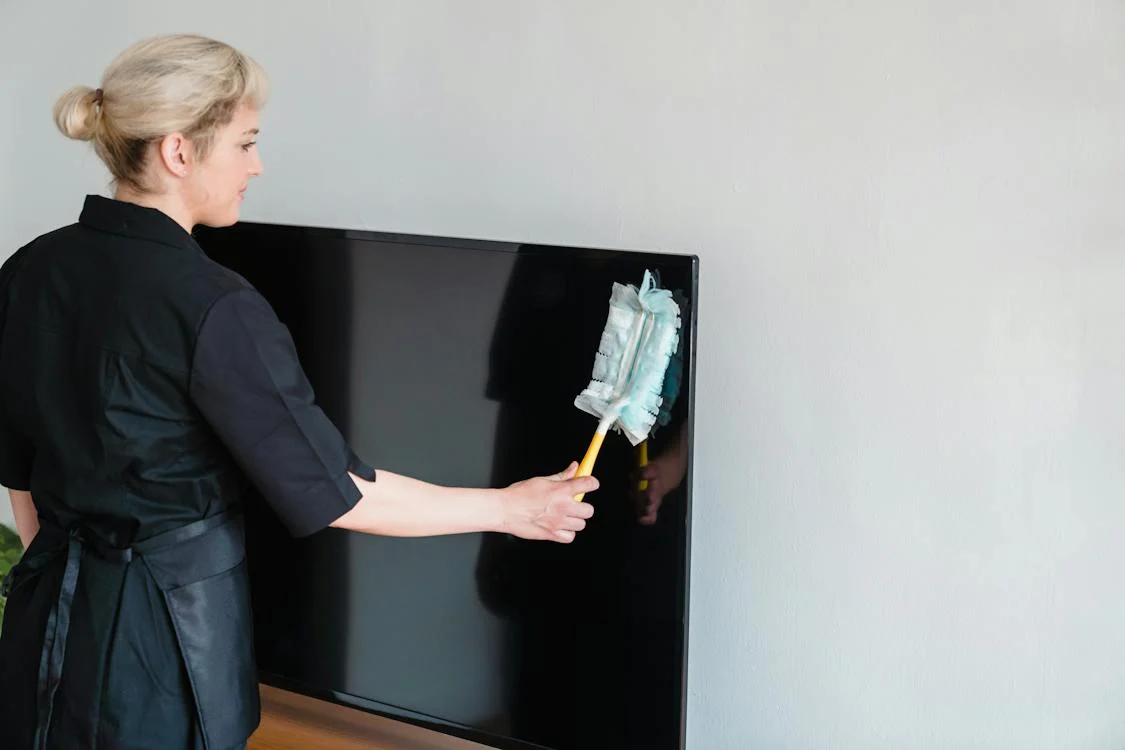 Lady cleaning a tv in Sammamish, WA.